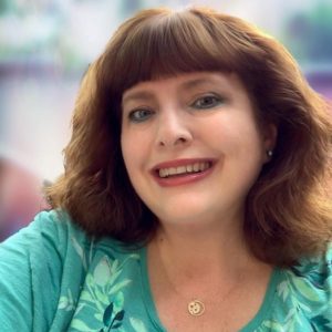 headshot of author Tabitha Gibson, who is a white woman with auburn hair.